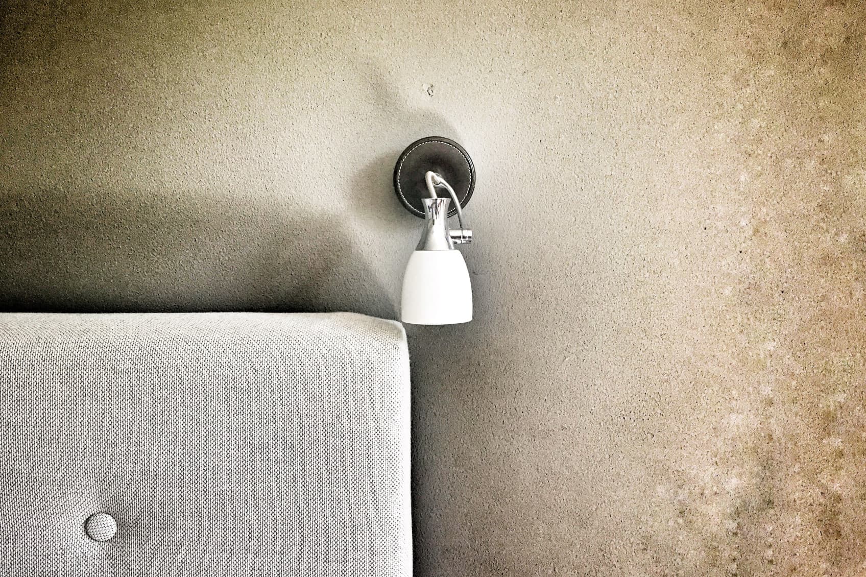 Detailaufnahme einer Lampe, die neben dem Bett auf der rechten Seite hängt