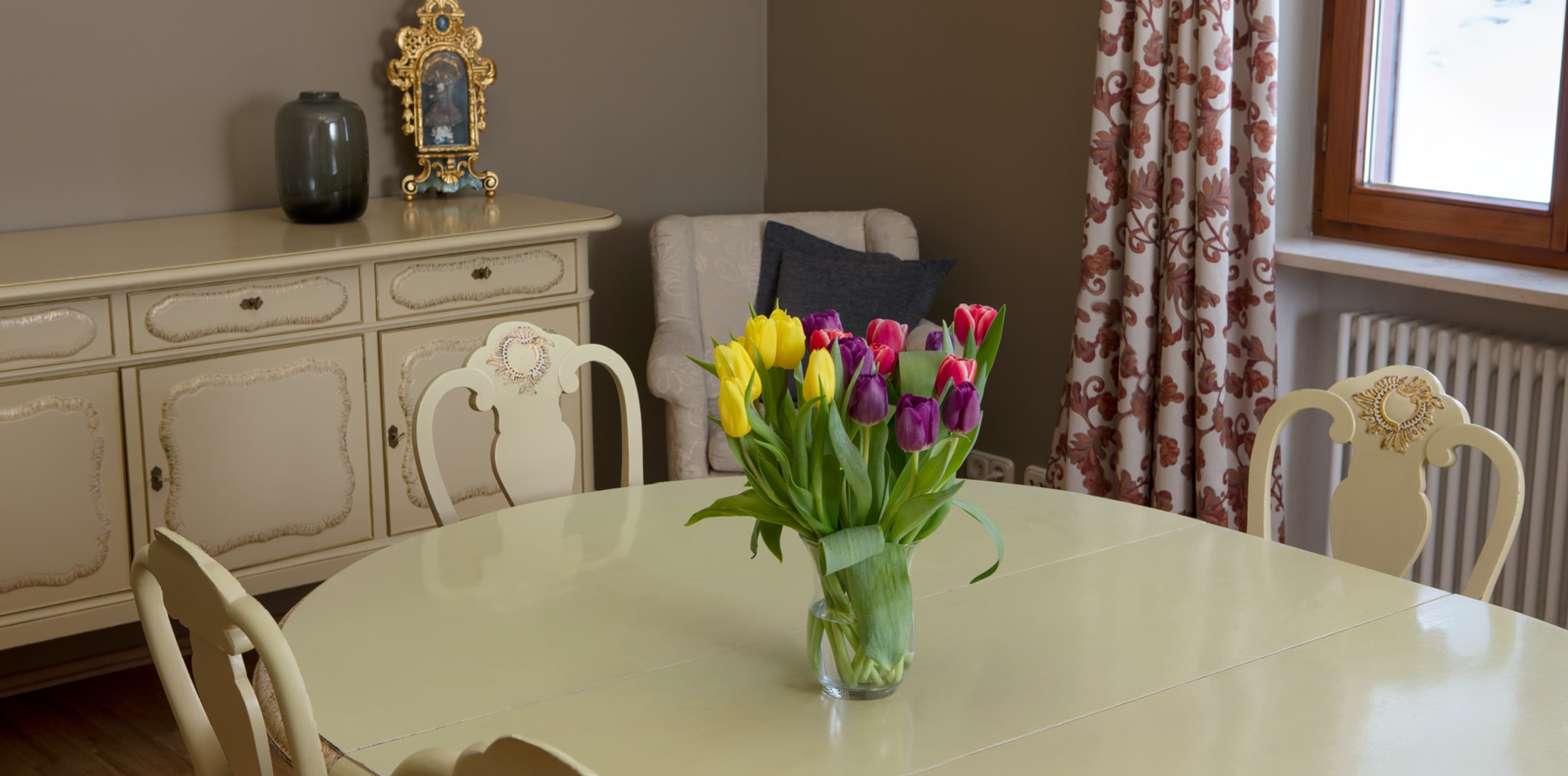 The community room in the hideauts hotels The rose garden with a bouquet of flowers on the table