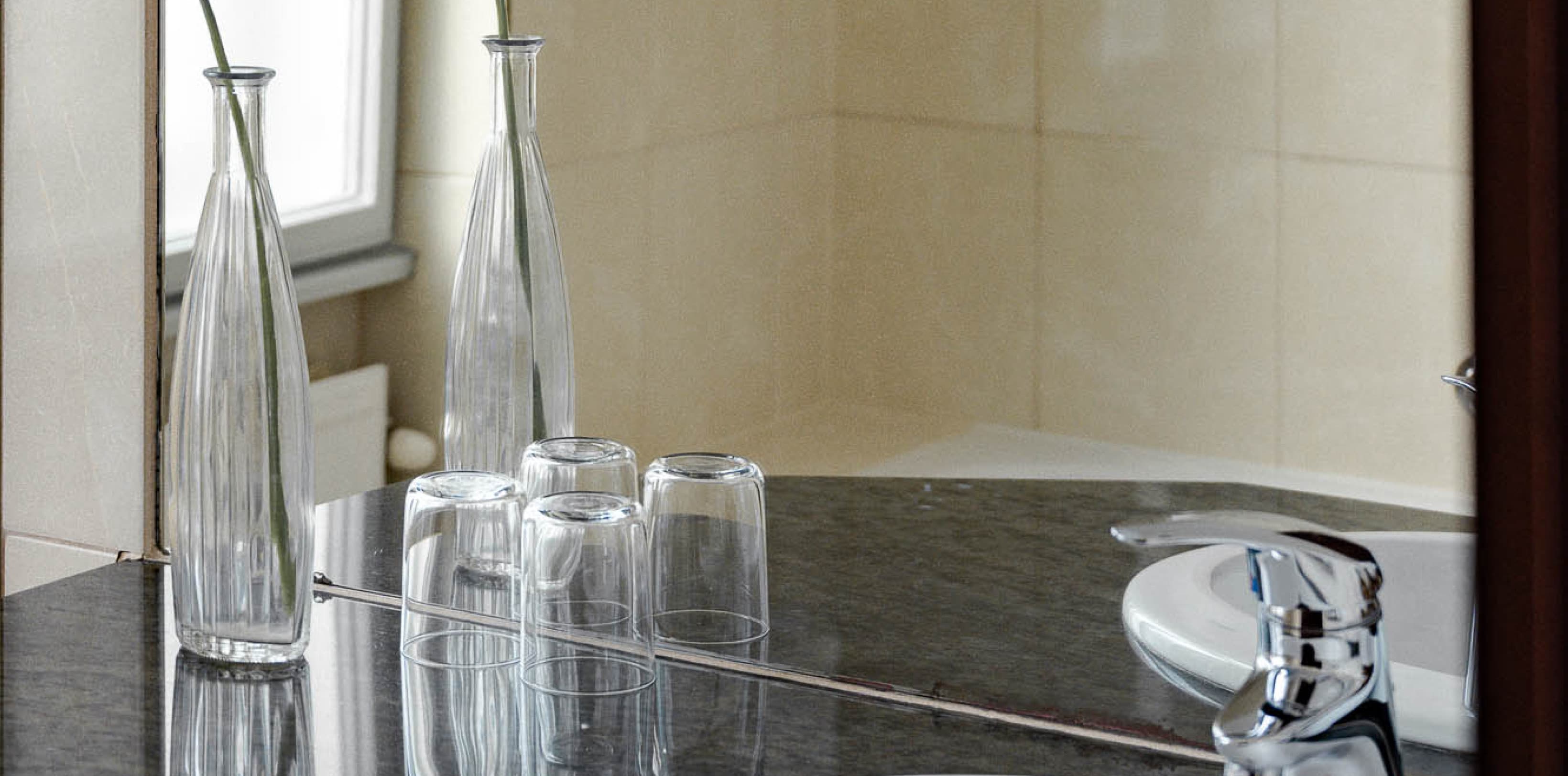 Alles, was Sie im Badezimmer brauchen, einschließlich eines großen Spiegels und Produkten von Saint Charles Apothecary.