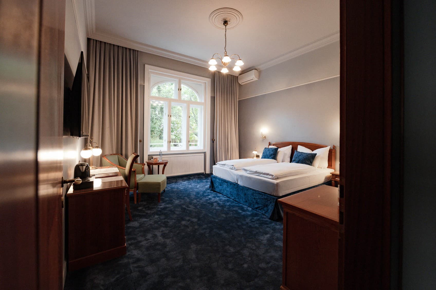 Pictured is a full view of the category Chic Garden View, which shows the double bed on the right hand side and the door to the balcony is straight ahead.