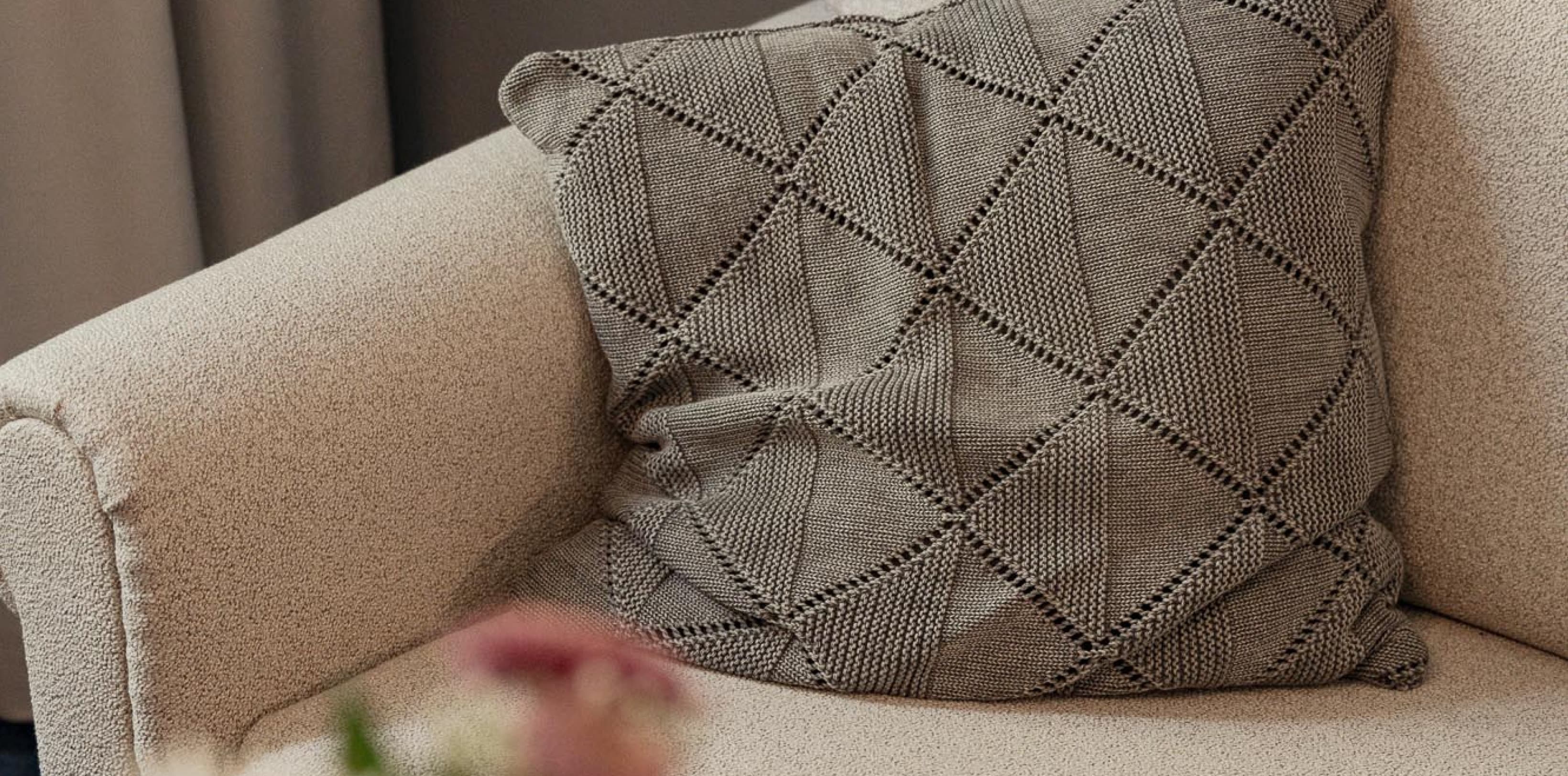 Seen is a prt of the couch that is opposite the bed and invites guests to relax and read a book after a day of sightseeing.