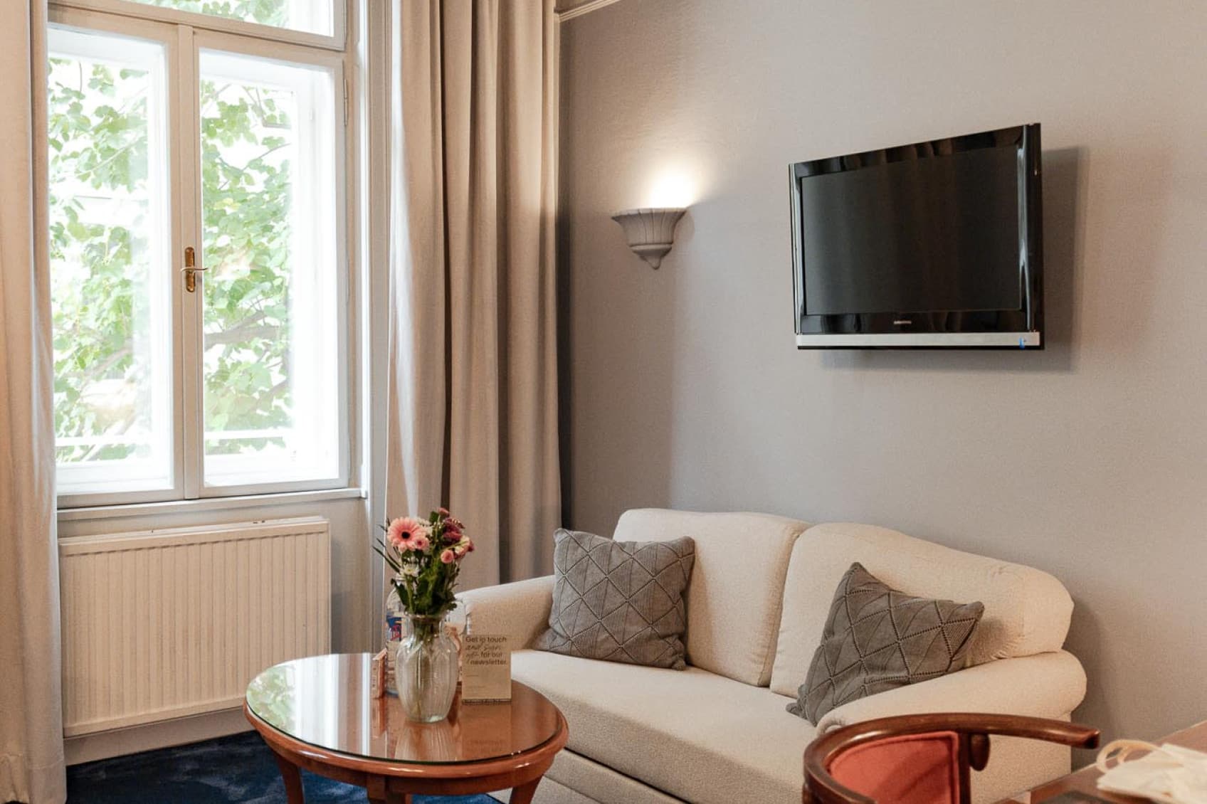 Seen is a wider shot of the leaving area of the room. Located opposite the bed, guests will find a couch as well as a desk to work at