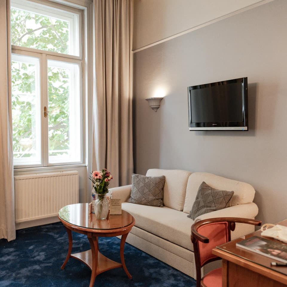 Seen is a wider shot of the leaving area of the room. Located opposite the bed, guests will find a couch as well as a desk to work at