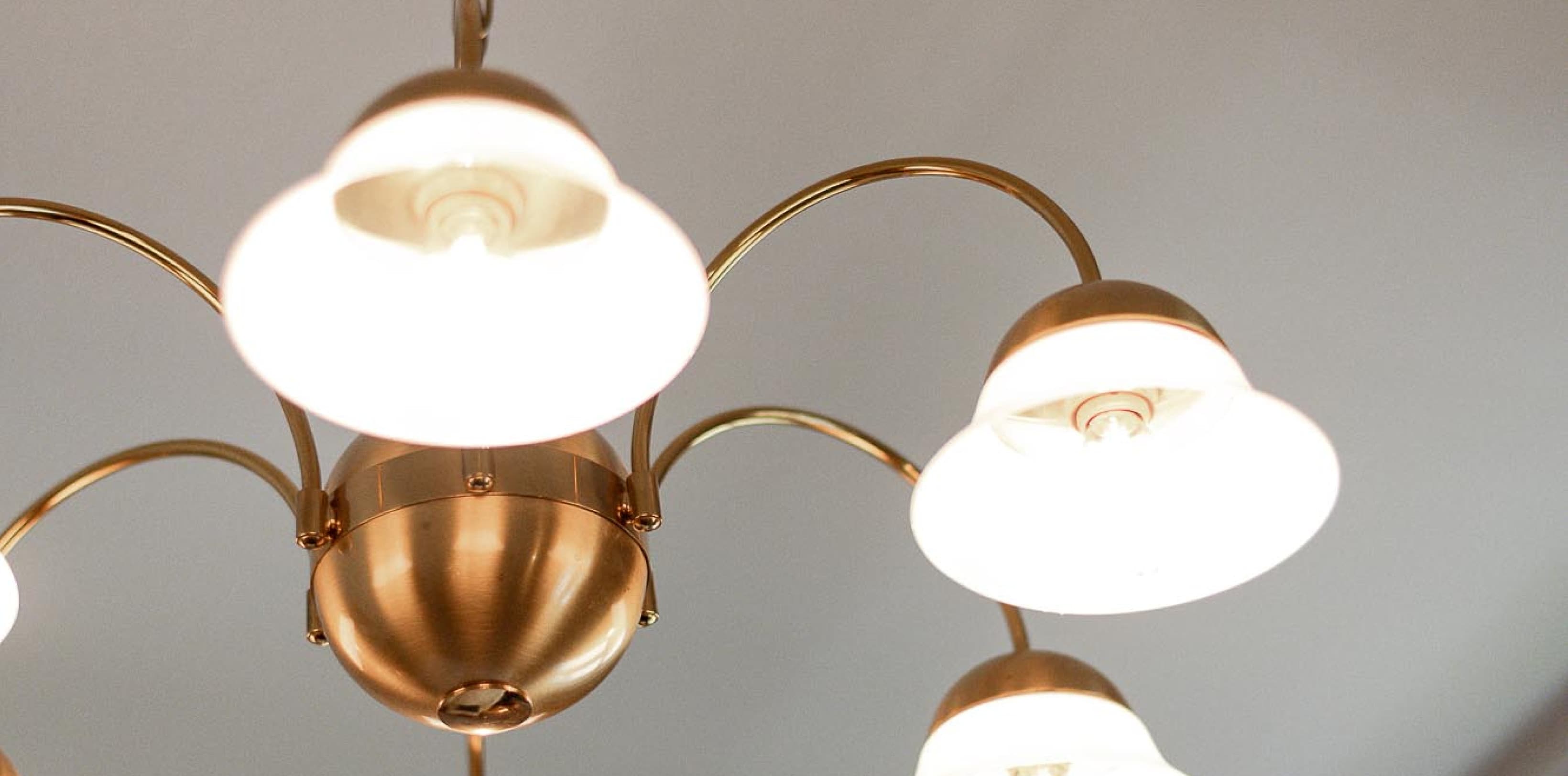 Seen is a detail shot of a restored golden chandelier, that shows the beauty and charme of the Viennese Villa