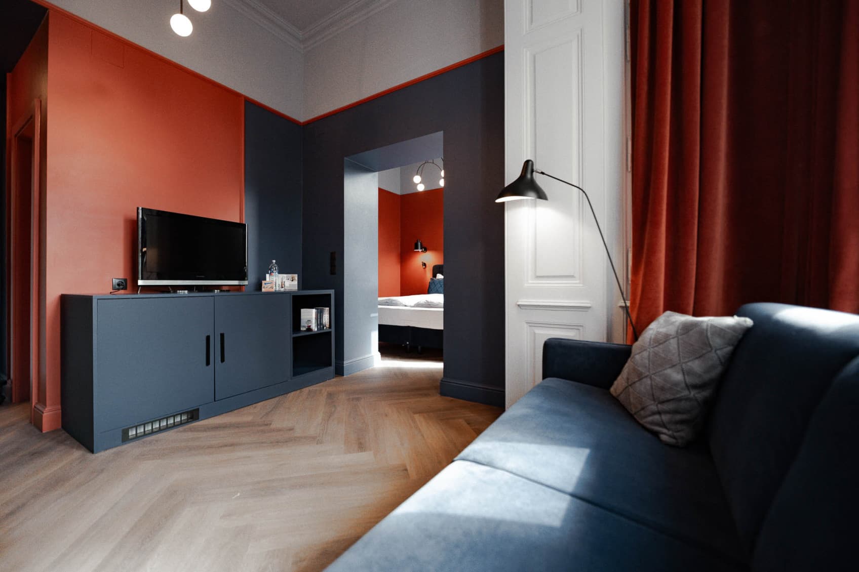 Seen is the Spacy category and the view from the couch towards the bedroom. The biggest category offers a bedrooma as well as seperated living room. The colours Orange and Blue are also present here.