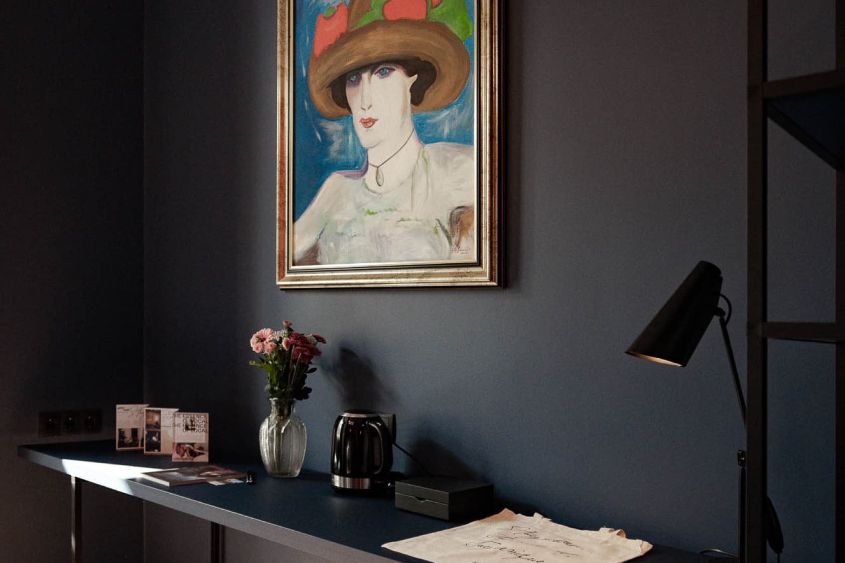 Part of the living area is a desk, that offers the opportunity to work at. The painting above it, shows a woman painted in a 20s style.