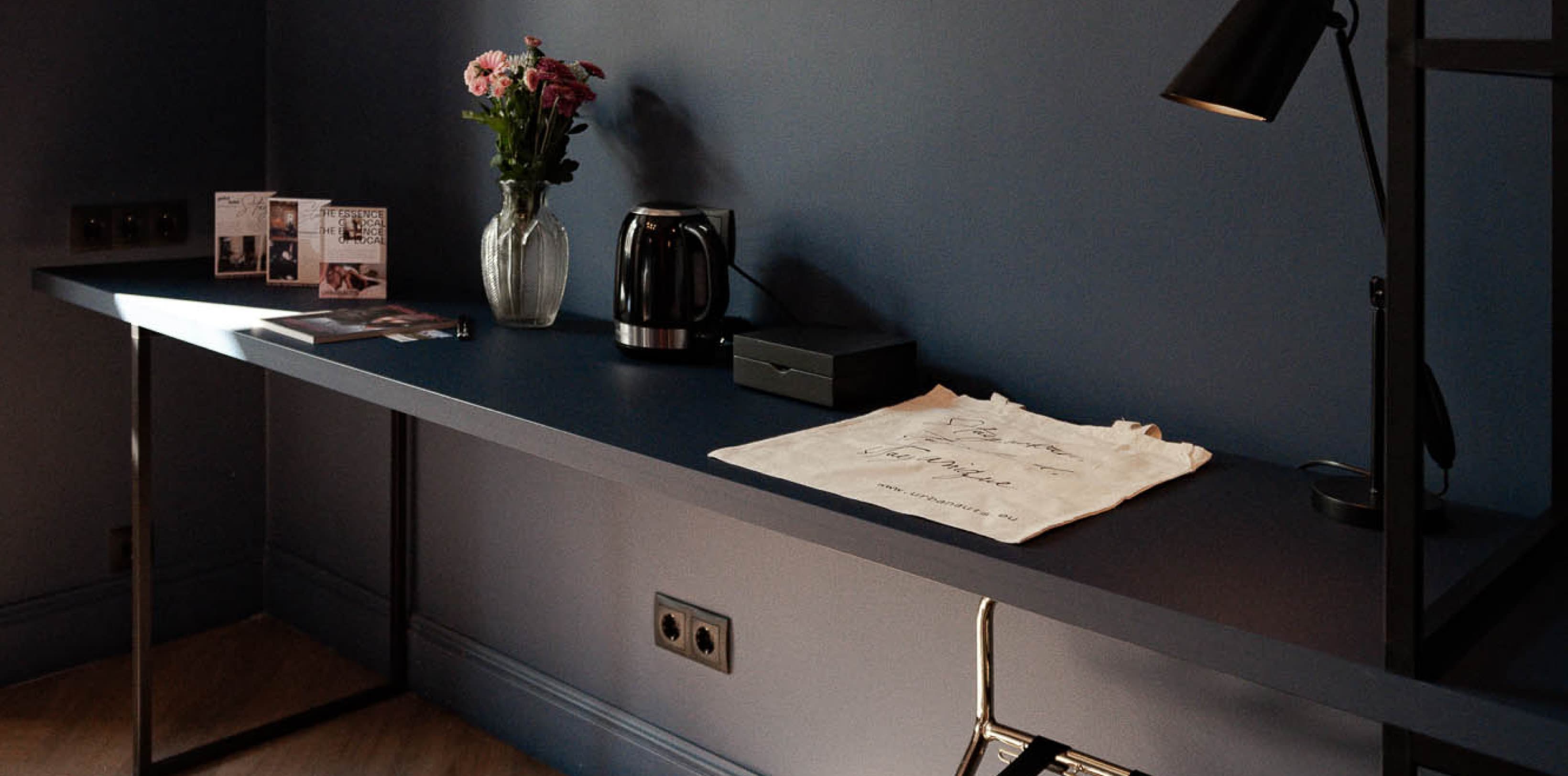 Ein Teil des Wohnbereichs ist ein Schreibtisch, an dem man arbeiten kann. Das Gemälde darüber zeigt eine Frau im Stil der 20er Jahre.