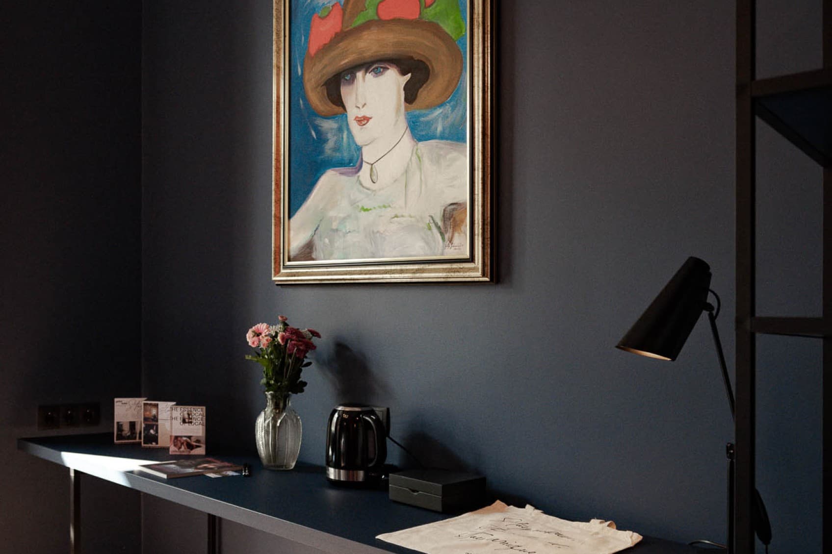 Part of the living area is a desk, that offers the opportunity to work at. The painting above it, shows a woman painted in a 20s style.
